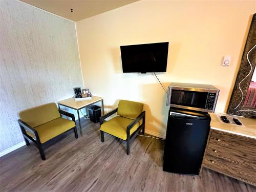 a hotel room with two chairs and a tv at Red Top Motor Inn in Iron Bridge