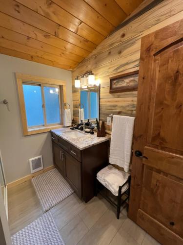 a bathroom with a sink and a chair in a cabin at Rustic 1 bd 1 ba Cabin at New Waitts Lake Resort in Valley