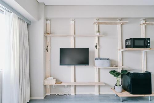 a living room with a tv and shelves at Shibuya Apartment Room Dogenzaka in Tokyo