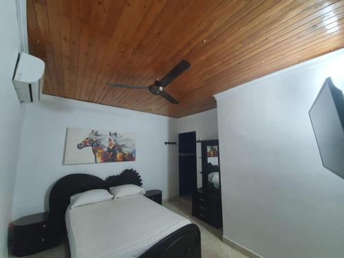 um quarto com uma cama e uma ventoinha de tecto em El rancho de arnolis em Cereté