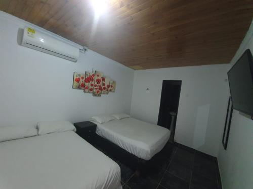 1 dormitorio pequeño con 2 camas y techo en El rancho de arnolis, en Cereté