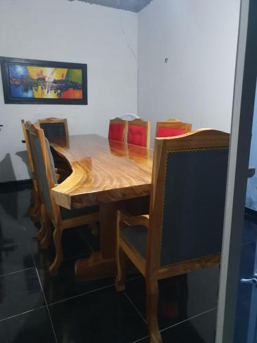 uma mesa de jantar em madeira com cadeiras e uma mesa em El rancho de arnolis em Cereté