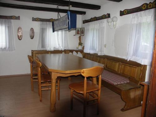 a dining room with a wooden table and chairs at Ferienwohnung im Bayerischen Wald für 10 Personen in Kollnburg