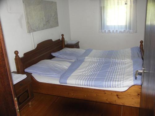 a bedroom with a bed with a blue and white comforter at Ferienwohnung im Bayerischen Wald für 10 Personen in Kollnburg