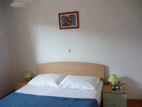 1 dormitorio con 1 cama y una foto en la pared en Wohnung in Barbat mit Terrasse und Grill en Barbat na Rabu
