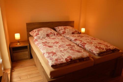 un letto con due cuscini e due lampade di Ferienhaus in Berkenlatten mit Großer Terrasse a Gerswalde