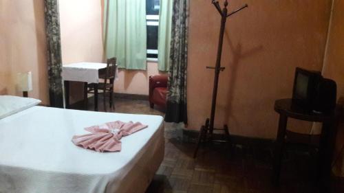 a bedroom with a bed with a pink towel on it at Varzea Palace Hotel in Teresópolis