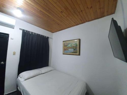 1 dormitorio con 1 cama y TV de pantalla plana en El rancho de arnolis, en Cereté