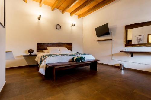 Palacio Del Cobre في تيبوزتلان: غرفة نوم مع سرير وتلفزيون على الحائط