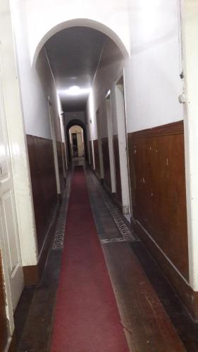 a long hallway with a red carpet in a building at Varzea Palace Hotel in Teresópolis