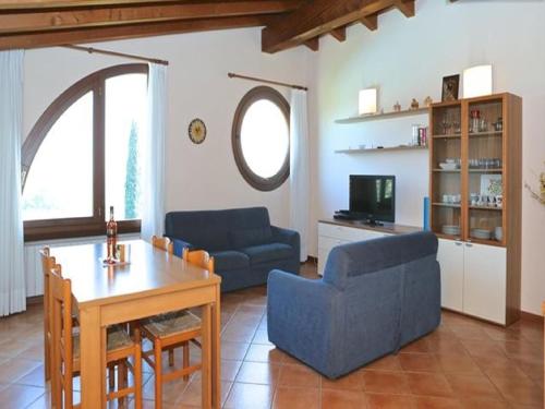 sala de estar con mesa y sofá azul en Appartement in Moniga Del Garda mit Grill, Garten und gemeinsamem Pool und Seeblick, en Moniga del Garda