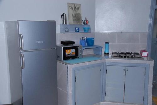 a small kitchen with a refrigerator and a microwave at Élégant Studio in Meknès
