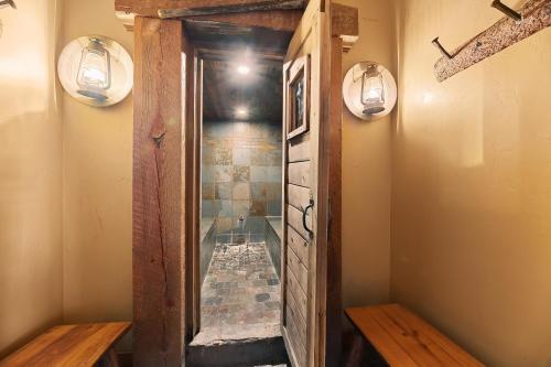 a bathroom with a walk in shower next to a mirror at Gold Rush Lodge in Lead