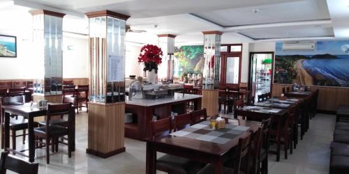 un restaurante con mesas y sillas en una habitación en Flora Quy Nhon Hotel, en Quy Nhon