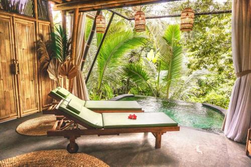 a patio with a chair and a swimming pool at Eco Bamboo Island Bali - Bamboo House #4 in Selat