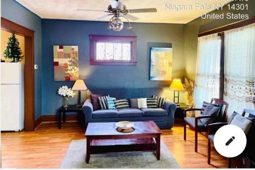 a living room with a blue couch and a table at Niagara View- Walnut Av 3 Bd & 2 F. Bth, Free 2prk in Niagara Falls