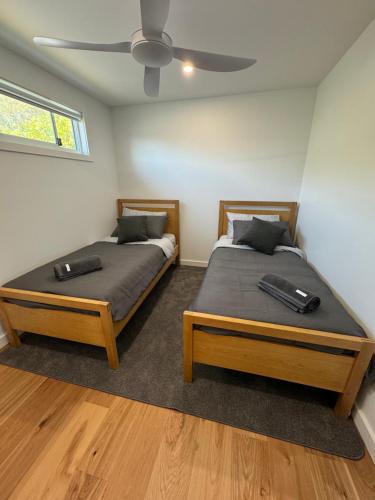 two twin beds in a bedroom with a ceiling at Eden Explorer - Beach - Bike - Hike - Fish in Eden