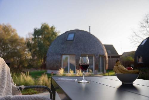 a glass of wine and a bowl of bananas on a table at Südkugel - Kugelhaus am See in Penzlin