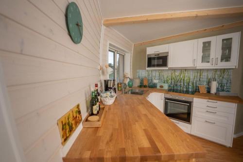 a kitchen with white cabinets and a wooden counter top at Südkugel - Kugelhaus am See in Penzlin