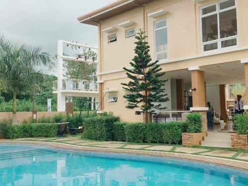 a house with a swimming pool in front of a house at Palawan Paradise Condotel 6F in Puerto Princesa City