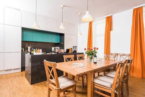 a kitchen and dining room with a wooden table and chairs at Komfortable Ferienwohnung für bis zu acht Personen im Erdgeschoss mit eigenem Garten in Vienna