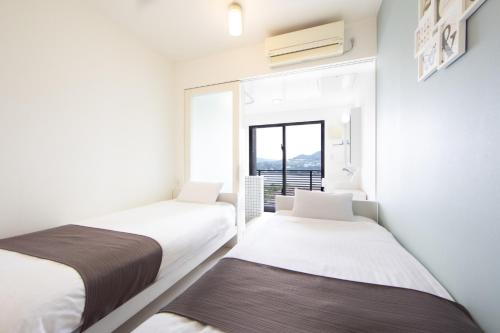 Duas camas num quarto com uma janela em E-horizon Resort Condominium Sesoko - Vacation STAY 92901v em Sesoko