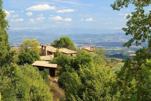 una casa en la cima de una colina con árboles en Wohnung auf zwei Etagen mit Studio und mit Balkonblick ins bergige Grüne, en Monte Vibiano Vecchio