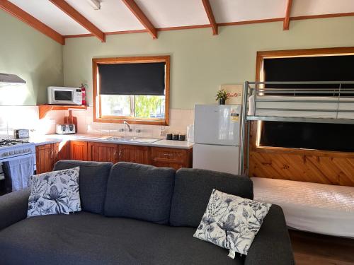 a living room with a couch and a kitchen at Millicent Lakeside Caravan Park in Millicent