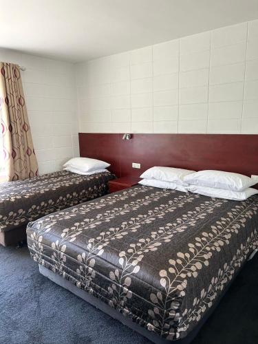 Ένα ή περισσότερα κρεβάτια σε δωμάτιο στο Tudor Motor Lodge