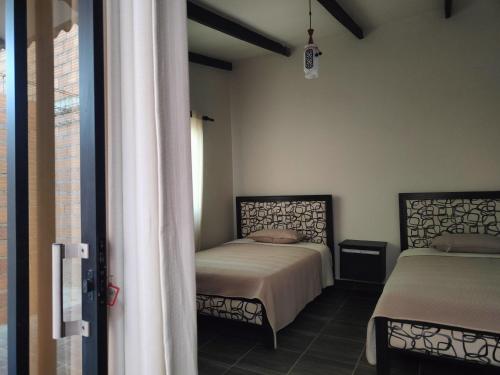 a bedroom with two beds and a window at HOSTEL BRISAS in Torotoro