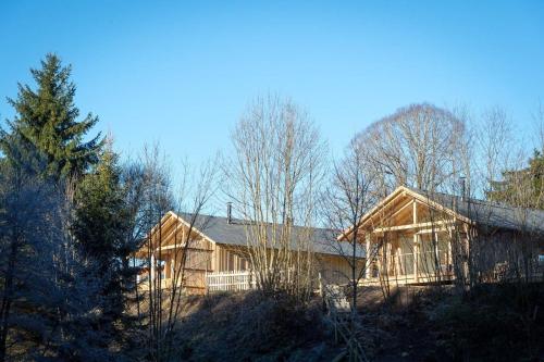 uma grande casa de madeira no meio de uma floresta em Ferienhaus für 2 Personen ca 87 qm in Regen-Kattersdorf, Bayern Bayerischer Wald em Regen