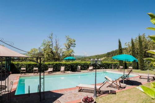 una piscina con sedie a sdraio e ombrelloni di Ferienhaus mit Privatpool für 6 Personen ca 120 qm in Lonnano, Toskana Provinz Arezzo a Pratovecchio