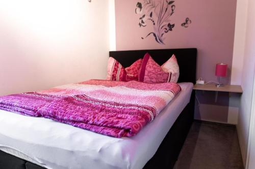 a bedroom with a bed with a purple blanket at Tolles Appartement in Weißenstadt mit Offenem Kamin in Weißenstadt