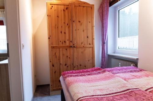 a bedroom with a wooden cabinet and a bed at Tolles Appartement in Weißenstadt mit Offenem Kamin in Weißenstadt