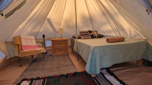 a bedroom in a tent with a bed and a chair at La Window Glamping in La Ventana