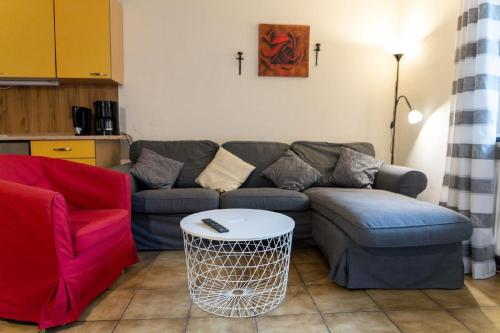 a living room with a couch and a table at Ferienwohnung mit Balkon, zwei Schlafzimmern und Küche mit Geschirrspülmaschine in Weißenstadt