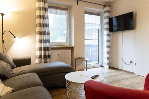 a living room with a couch and a table at Ferienwohnung mit Balkon, zwei Schlafzimmern und Küche mit Geschirrspülmaschine in Weißenstadt