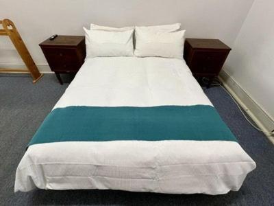 een slaapkamer met een wit bed en 2 nachtkastjes bij The Exchange Pingelly in Pingelly