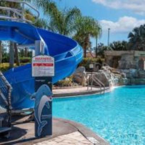 a dolphin water slide in a pool at a resort at Beautiful Townhome just 8 miles from Disney in Kissimmee