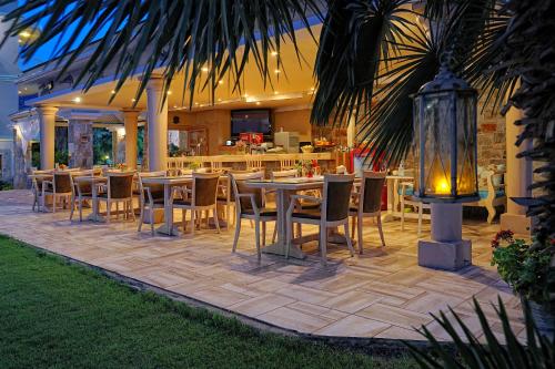 a restaurant with tables and chairs on a patio at Socrates Hotel Malia Beach in Malia