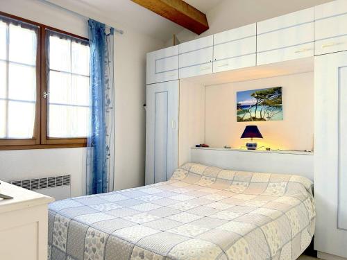 Habitación blanca con cama y ventana en Maison Bormes-les-Mimosas, 2 pièces, 4 personnes - FR-1-251-649, en Bormes-les-Mimosas