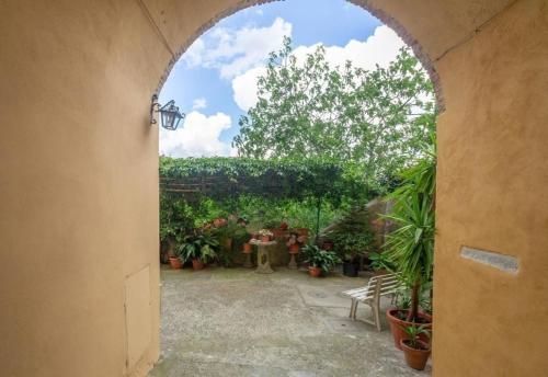 um arco que conduz a um jardim com vasos de plantas em Ferienwohnung Le Volte in der Residenza dei Piaceri Perduti em Lastra a Signa