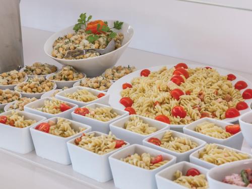 a display of pasta and vegetables in white containers at MH Peniche in Peniche