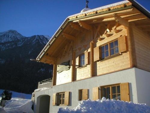 un edificio en la nieve con montañas en el fondo en Ferienhaus in Sautens mit Garten, Pool und Grill und Panoramablick en Sautens