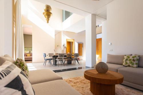 ein Wohnzimmer mit einem Sofa und einem Tisch in der Unterkunft 5-Suite Villa with Private Pool in Marrakesch