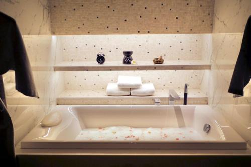 a bathroom with a bath tub with a sink at Karon Island Boat Boutique Hotel in Patong Beach