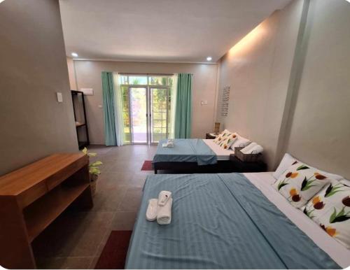 - une chambre d'hôtel avec 2 lits avec des chaussures dans l'établissement Fins Pacific Coray Bay by Hiverooms, à Samboan