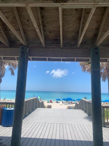 un paseo marítimo que conduce a la playa con sombrillas en Lake Marlin Villa, en Port Charlotte