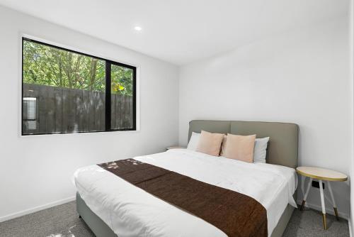 a bedroom with a large bed and a window at Modern Sunny 3Bed 2.5Bath in Christchurch
