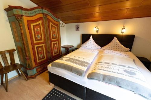 a bedroom with a large bed with a wooden headboard at Charmante Ferienwohnung in Gemeinde Flattach mit Beheiztem gemeinsamem Pool in Flattach